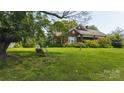 Charming brick home with a large front yard, mature trees, and a porch swing at 1040 Nc 90 W Hwy, Taylorsville, NC 20681