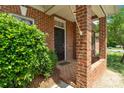 Close-up of a brick front porch and black front door with a well-maintained shrub at 1141 Ardwyck Pl, Rock Hill, SC 29730