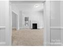 Spacious living room featuring neutral walls, carpet flooring, and a cozy brick fireplace at 115 W 5Th Ave, Gastonia, NC 28052