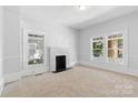 Bright living room boasting fresh paint, neutral carpet, a decorative fireplace and natural light from large windows at 115 W 5Th Ave, Gastonia, NC 28052