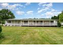 Charming home featuring a wide, inviting porch with white railings and green shutters, surrounded by a lush green lawn at 1720 Lowe Dr, Catawba, NC 28609