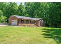 Charming brick home with a well-manicured lawn and lush greenery, with an attached two-car garage at 174 Buena Vale Dr, Gastonia, NC 28056
