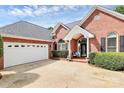 Inviting brick home with a white two car garage and a covered entry featuring arched windows and a decorative door at 2289 Veery Ln, Rock Hill, SC 29732