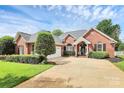 Charming red brick home featuring a well-manicured front yard and a two-car garage with a concrete driveway at 2289 Veery Ln, Rock Hill, SC 29732