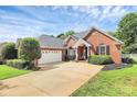 Beautiful brick home with a well-maintained lawn, a two-car garage, and a comfortable bench on the front porch at 2289 Veery Ln, Rock Hill, SC 29732