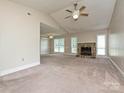 Bright living room with vaulted ceiling, ceiling fan, stone fireplace and large windows at 2919 Peachwood Ct, Fort Mill, SC 29715