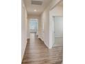 Bright hallway with wood floors leading to various rooms, showcasing the home's open layout at 3662 Charles Nw St, Conover, NC 28613