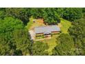 Aerial view showcases a brick home nestled among trees with a well-maintained yard at 6215 Simpson Rd, Charlotte, NC 28216