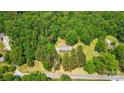 Aerial view showcases a brick home nestled among mature trees on a spacious lot at 6215 Simpson Rd, Charlotte, NC 28216