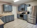 Well lit kitchen featuring stainless steel appliances, blue cabinets, and light countertops at 632 Pawley Dr, Charlotte, NC 28214