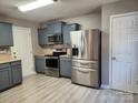 Well lit kitchen featuring stainless steel appliances, blue cabinets, and light countertops at 632 Pawley Dr, Charlotte, NC 28214
