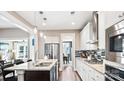Modern kitchen features stainless steel appliances, granite counters, and eat-in island with hanging lights at 7017 Treetop Ct, York, SC 29745