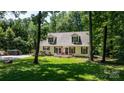 Inviting home with dormer windows, front porch, wood deck and surrounded by mature trees and lush lawn at 7648 Forest Oak Dr, Denver, NC 28037