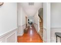 Bright hallway featuring hardwood floors, decorative molding, and a staircase to the upper level at 8414 Oak Ne Dr, Charlotte, NC 28269
