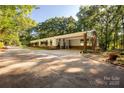A single-story brick and white plank home with a carport and a long, winding driveway at 981 Sherwood Cir, Lancaster, SC 29720