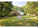 Charming single-story home with lush lawn, mature trees, and a welcoming walkway to the front door at 981 Sherwood Cir, Lancaster, SC 29720
