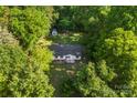 Aerial view of a home nestled in a lush, green, wooded area with a storage shed in the backyard at 1055 Cedar Hill Dr, Rockwell, NC 28138