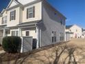 Side view of light siding two-story townhome with a well-maintained yard and blue sky above at 11622 Lioness St, Charlotte, NC 28273