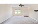 Bright living room featuring neutral carpeting, modern ceiling fan, and ample natural light at 1175 Valley St # 111, Statesville, NC 28677