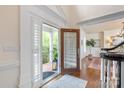 Inviting foyer with hardwood floors, decorative rug, and elegant glass front door at 12048 Royal Portrush Dr, Charlotte, NC 28277
