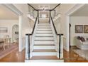 Elegant staircase with dark wood railings and white risers creates a grand entrance at 12048 Royal Portrush Dr, Charlotte, NC 28277