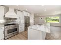 Modern kitchen features stainless steel appliances, island, and marble countertops at 1208 Tarrington Ave, Charlotte, NC 28205
