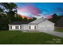 New construction home shows off a well manicured lawn, dual garage, and classic white color scheme at 13109 Homewood Dr, Charlotte, NC 28262