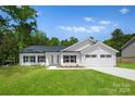 Beautiful new construction home featuring manicured lawn, 2-car garage, and classic white color scheme at 13109 Homewood Dr, Charlotte, NC 28262