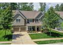 Charming two-story home with manicured lawn, two-car garage, and inviting front porch at 135 Canoe Pole Ln, Mooresville, NC 28117