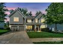 Beautiful two-story home featuring a well-lit exterior, manicured lawn, and inviting front porch at 135 Canoe Pole Ln, Mooresville, NC 28117