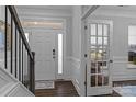 Bright foyer with white door, stairs, wainscoting, and transom window providing a grand entrance to the home at 154 Cotton Field Dr, Statesville, NC 28677