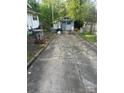 View of the cracked concrete driveway, storage shed, and backyard at 216 Maple St, Statesville, NC 28677