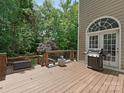Spacious back deck with stairs, grill, and wooded view, perfect for outdoor entertaining at 3721 Providence Plantation Ln, Charlotte, NC 28270