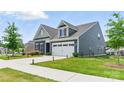 Side view of a charming home featuring a manicured lawn and a two-car garage at 4069 Havenport Cir, Tega Cay, SC 29708