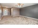 Spacious living room featuring neutral walls, carpet, a ceiling fan, and an exterior door at 4751 Kemp Dellinger Rd, Maiden, NC 28650