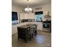 Modern kitchen with a large island, stainless steel appliances, and a stylish chandelier for a sophisticated look at 642 Boger St, Mooresville, NC 28115
