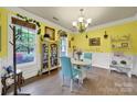 Charming dining area featuring a display case, large windows, and cheerful yellow walls at 7710 Grove Hall Ave, Mint Hill, NC 28227