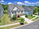Aerial view of a two-story home showcasing its manicured lawn, stone accents, and surrounding neighborhood at 1001 Emory Ln, Fort Mill, SC 29708