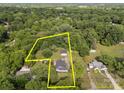 Aerial view of property featuring mature trees, home and detached garage outlined in yellow at 1001 Old Charlotte Rd, Concord, NC 28027