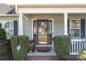 Close up of front door featuring beautiful wreath, lovely landscaping, and traditional architectural details at 1002 4Th Ne St, Conover, NC 28613