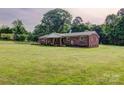 Single-story brick home with a large, lush front yard and mature trees on a spacious lot at 1009 High Shoals Rd, Lincolnton, NC 28092
