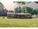 Well-maintained ranch home featuring a classic brick facade and a spacious, green front lawn at 1009 High Shoals Rd, Lincolnton, NC 28092
