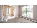 Bright living room with carpet, large window offering natural light and view into an adjoining space at 10146 Hawkeye Dr # 2, Charlotte, NC 28273