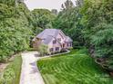 Aerial view of a brick home with lush green landscaping and a long driveway at 112 Eagle Chase Ln, Troutman, NC 28166