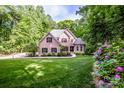 Beautiful brick home surrounded by green lawn and colorful purple rhododendrons at 112 Eagle Chase Ln, Troutman, NC 28166