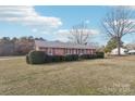 A view of the property showing the brickwork, shutters, and tree-lined yard, lending a quiet, suburban charm at 1177 Craigbrow Cir, Chester, SC 29706