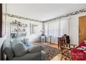 Bright living room with a cozy sofa, large window, decorative wallpaper border, and a stylish display shelf at 1177 Craigbrow Cir, Chester, SC 29706