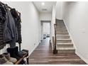 Inviting entryway with hardwood floors, coat rack, and staircase leading to the upper level at 1206 Keydet Dr, Charlotte, NC 28216
