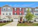 Charming townhome featuring colorful siding, a driveway, manicured lawn, and a covered front porch at 1206 Keydet Dr, Charlotte, NC 28216