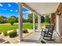 Relaxing front porch with rocking chair, brick accents, and landscaped yard overlooking a lush green lawn at 1305 Glenview Ln, Rock Hill, SC 29730